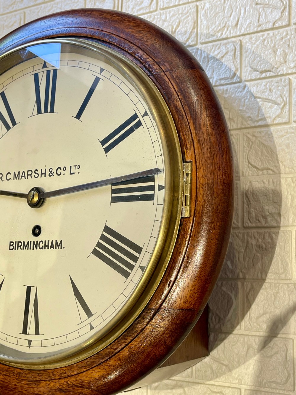 A circular Victorian oak fusee wall clock featuring a white dial with Roman numerals, black hands, and a brass bezel. View XI