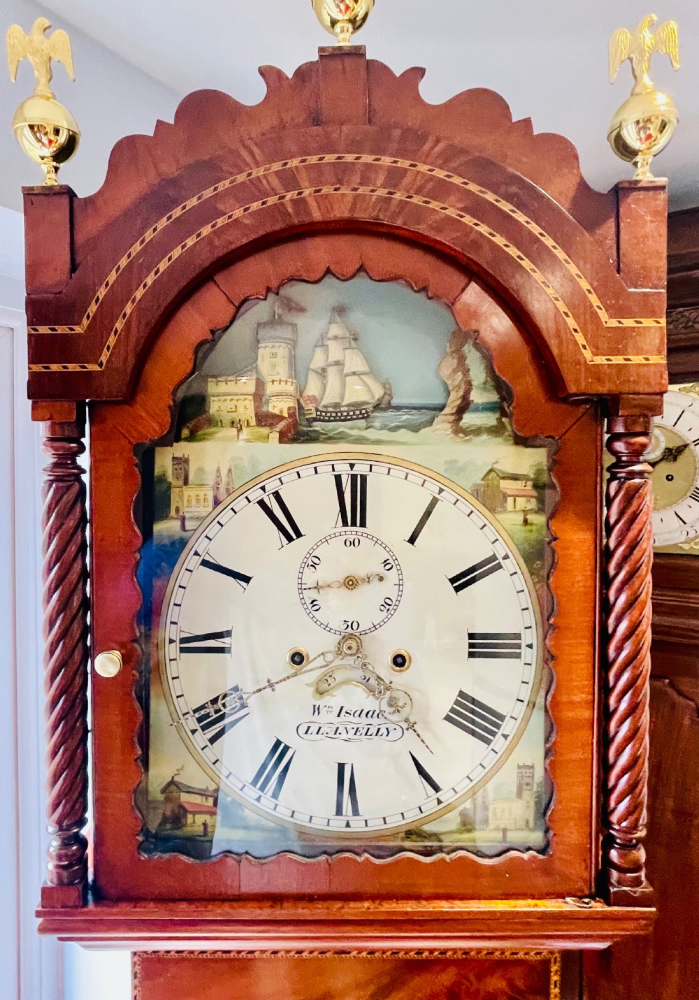 An antique Welsh mahogany longcase clock featuring a painted dial with a rocking ship automaton arch and brass finials. View II