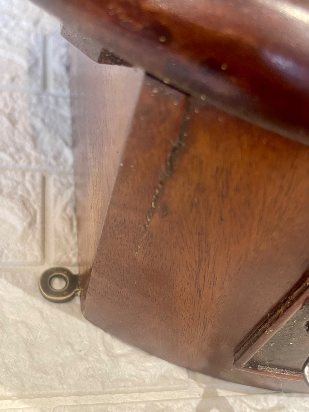 A circular Victorian oak wall clock featuring a cream painted dial with Roman numerals, black hands, a brass bezel, and the maker inscription Butcher, Wellingborough. View VIII