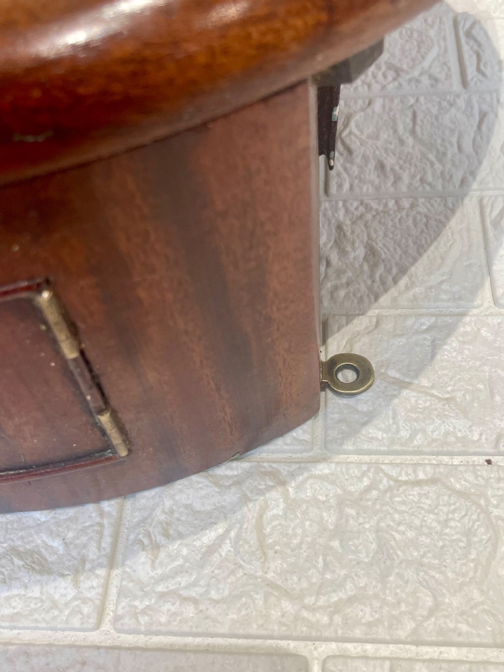 A circular Victorian oak wall clock featuring a cream painted dial with Roman numerals, black hands, a brass bezel, and the maker inscription Butcher, Wellingborough. View IX