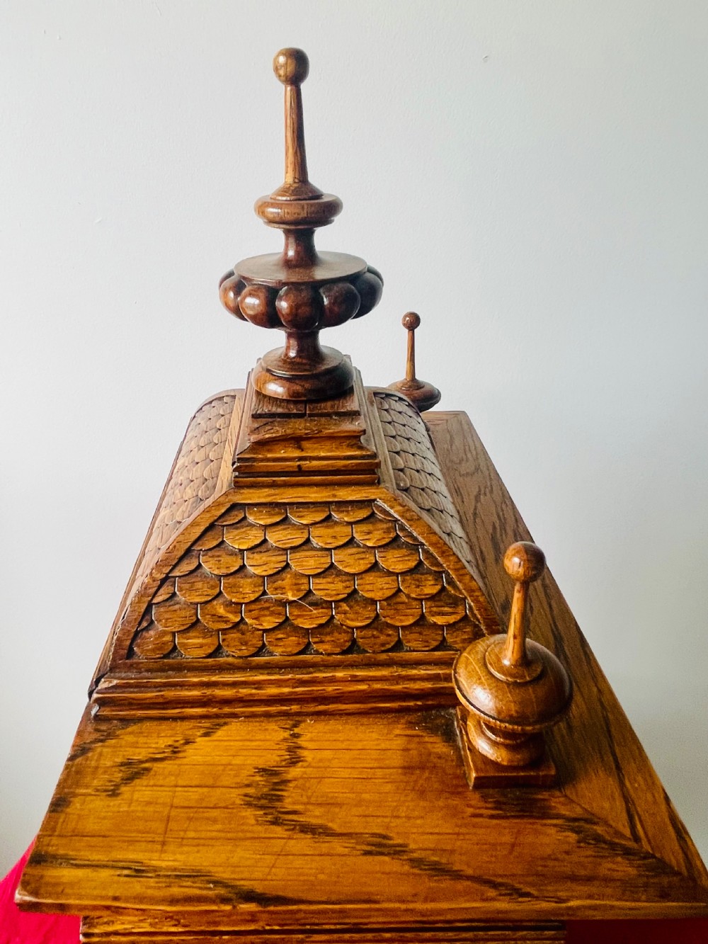 An antique carved oak bracket clock featuring finials, turned columns, and a brass dial with silvered chapter ring. View VIII