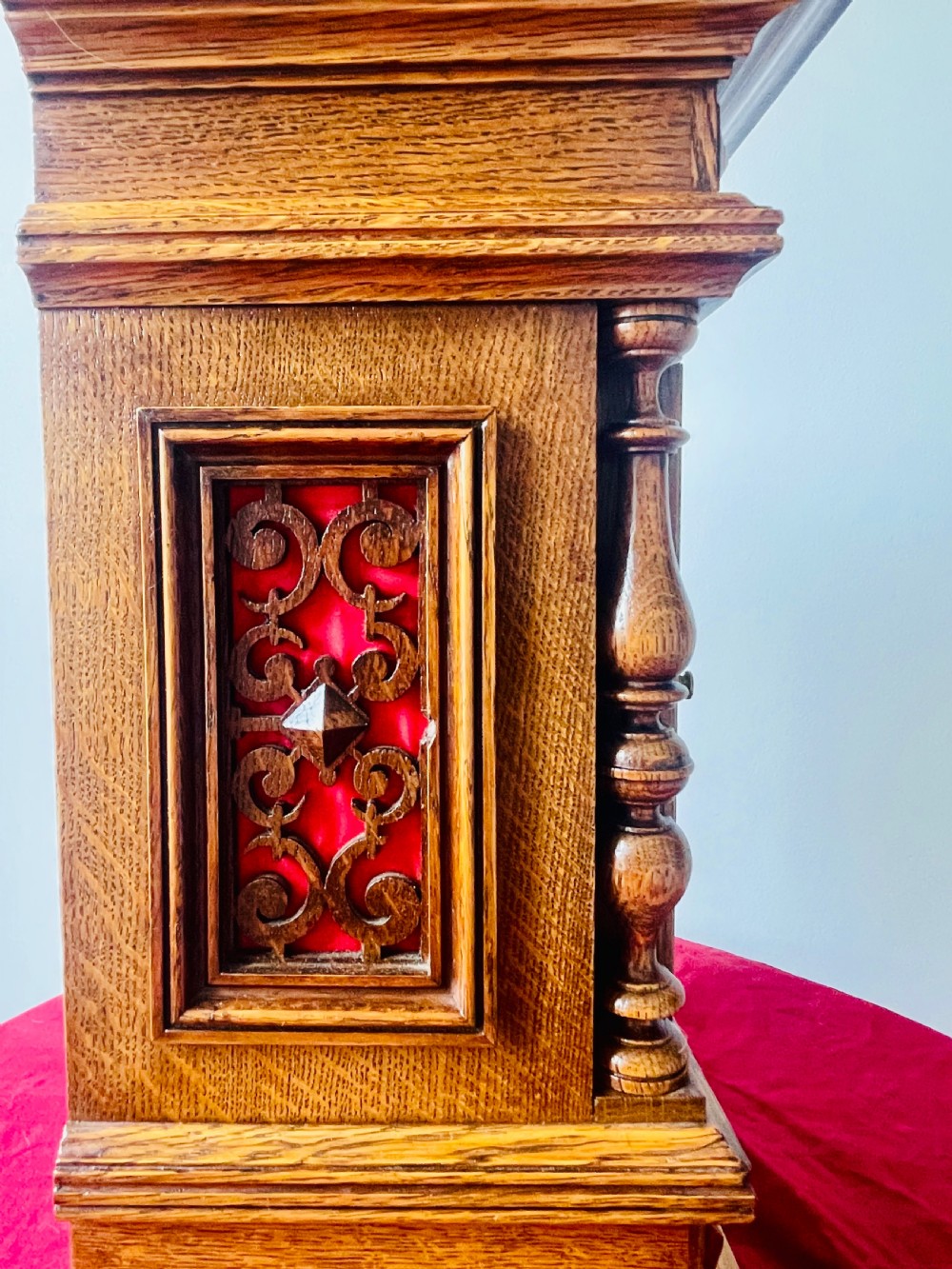 An antique carved oak bracket clock featuring finials, turned columns, and a brass dial with silvered chapter ring. View XVI