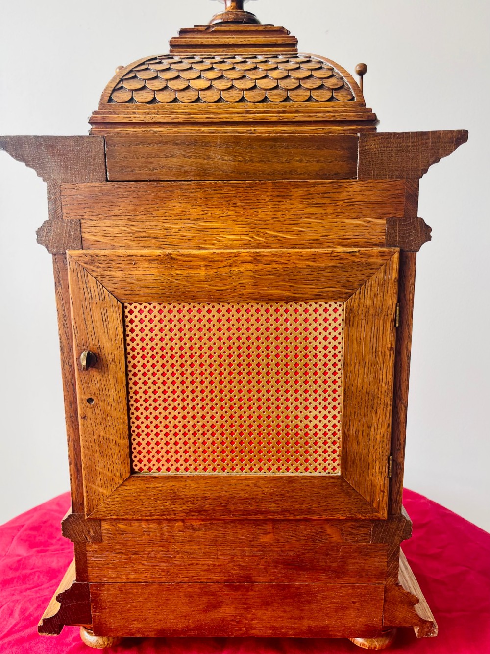 An antique carved oak bracket clock featuring finials, turned columns, and a brass dial with silvered chapter ring. View XIX