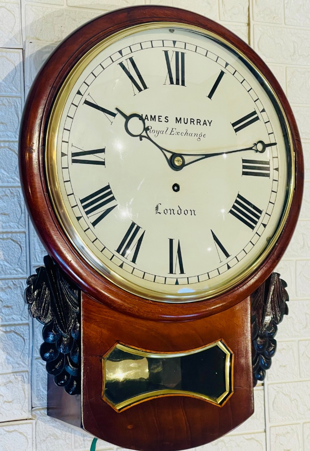A mahogany drop dial fusee wall clock with a circular white dial signed James Murray London, black Roman numerals, a brass bezel, and carved side details. View VIII