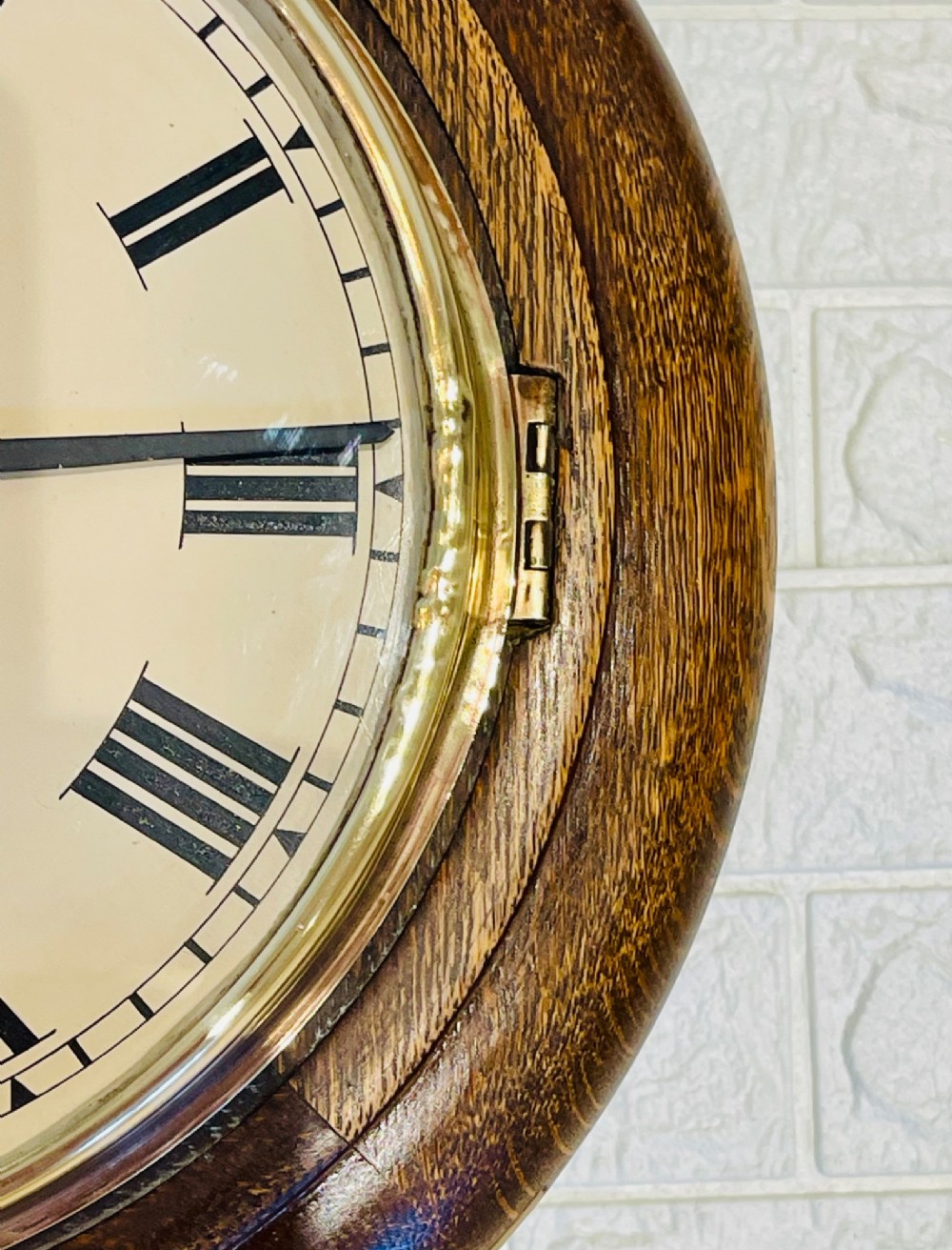 A circular oak wall clock featuring a brass bezel, Roman numerals, and British Rail markings printed on the dial. View V