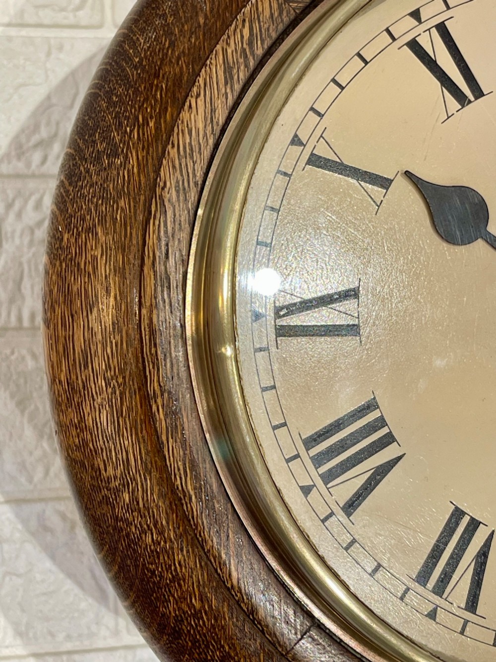 A circular oak wall clock featuring a brass bezel, Roman numerals, and British Rail markings printed on the dial. View VII