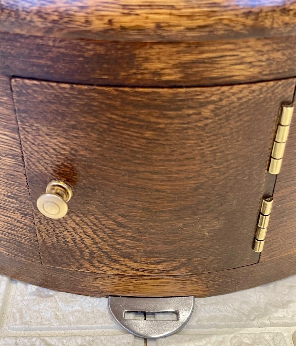 A circular oak wall clock featuring a brass bezel, Roman numerals, and British Rail markings printed on the dial. View X