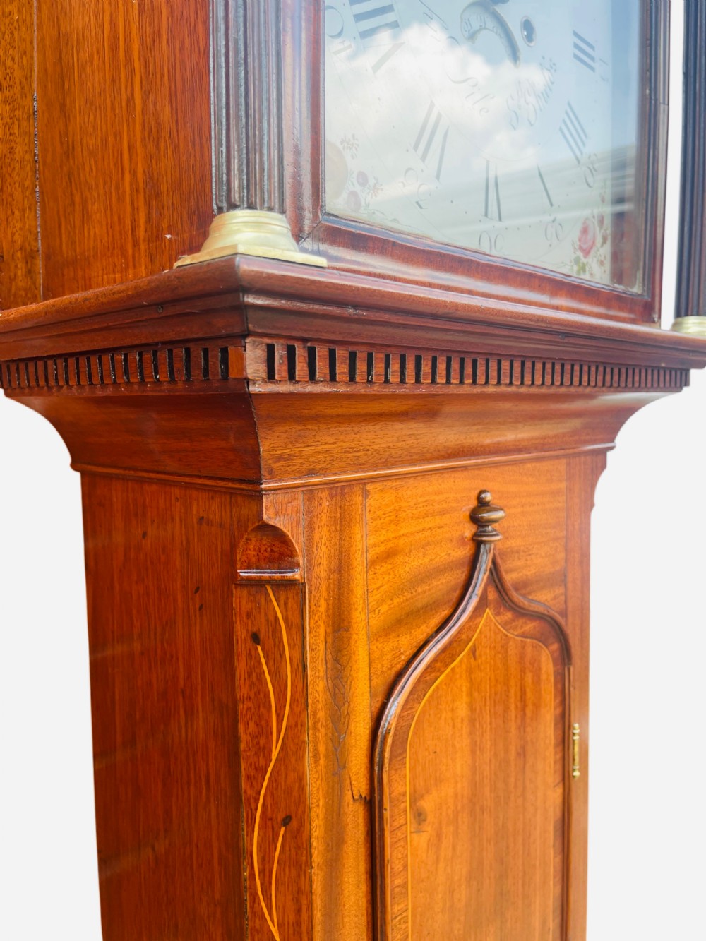 A Georgian oak longcase clock featuring a fretwork pediment, brass finial, hand-painted dial with Roman numerals, and an arched waist door. View VII