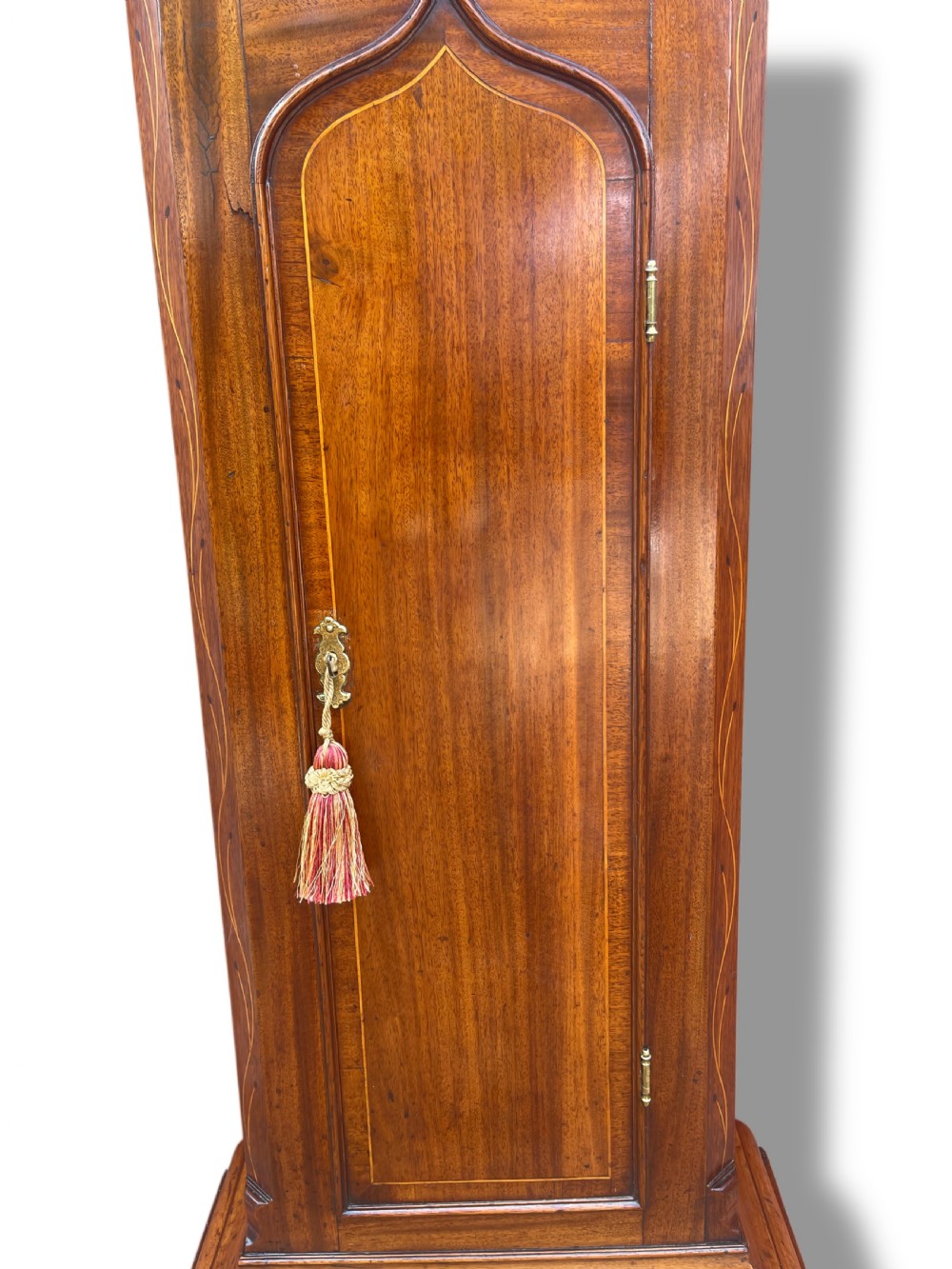 A Georgian oak longcase clock featuring a fretwork pediment, brass finial, hand-painted dial with Roman numerals, and an arched waist door. View XXII