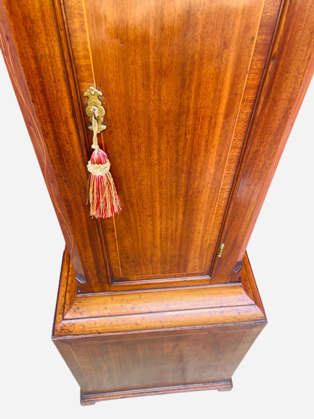 A Georgian oak longcase clock featuring a fretwork pediment, brass finial, hand-painted dial with Roman numerals, and an arched waist door. View XXIII