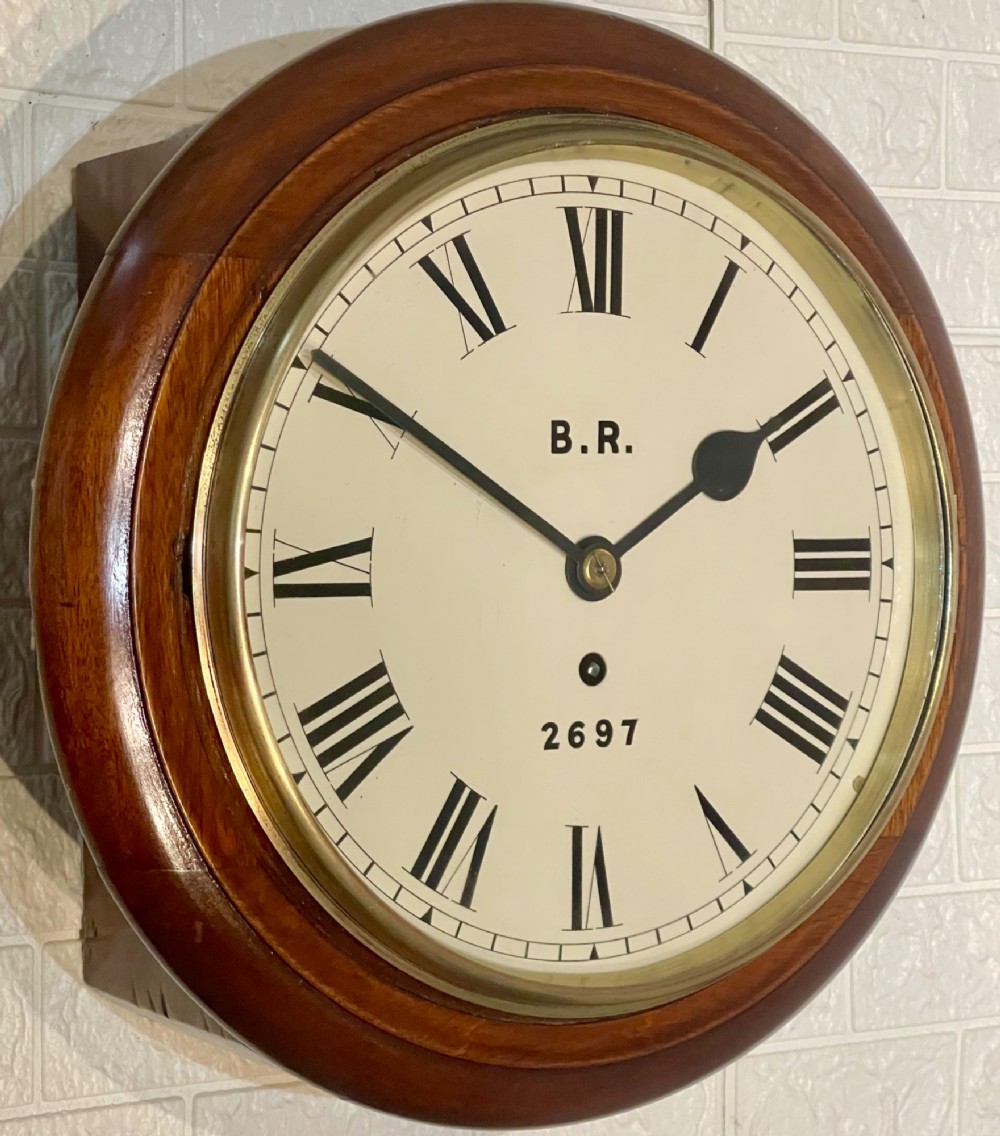 A circular antique mahogany fusee wall clock featuring a cream dial marked B.R., Roman numerals, black hands, and a brass bezel.