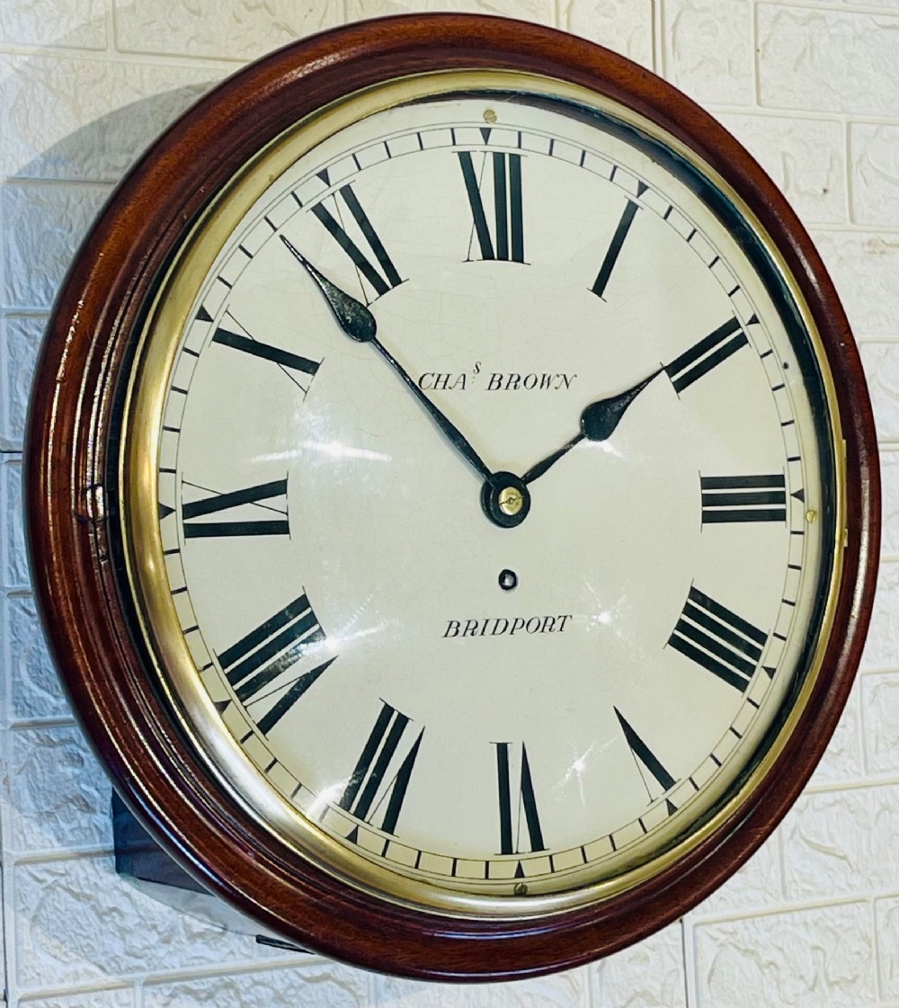 A circular Georgian fusee wall clock with a dark mahogany frame, a cream painted dial with Roman numerals, and a polished brass bezel. View II