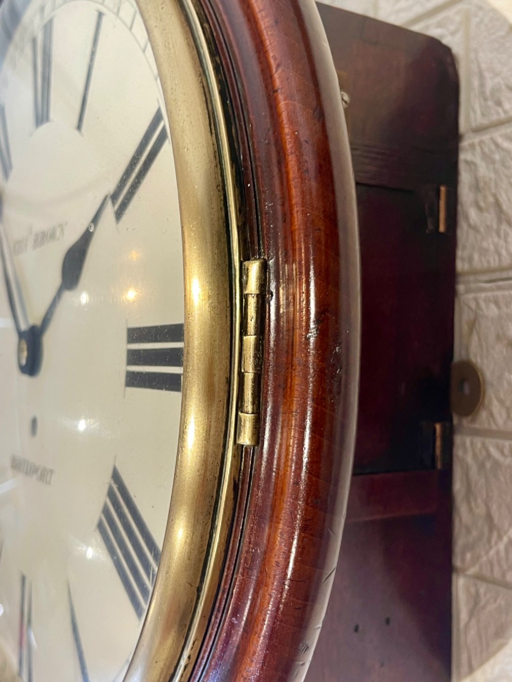 A circular Georgian fusee wall clock with a dark mahogany frame, a cream painted dial with Roman numerals, and a polished brass bezel. View IV