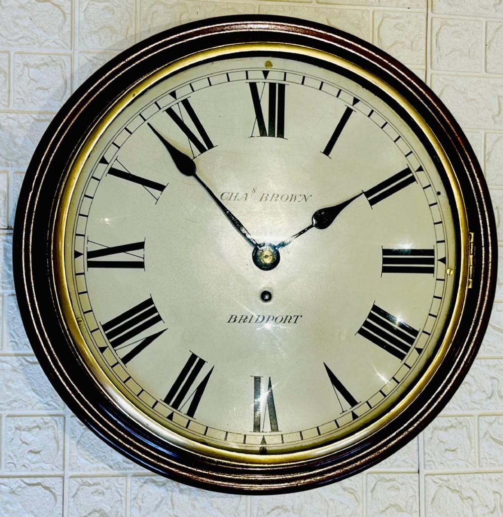 A circular Georgian fusee wall clock with a dark mahogany frame, a cream painted dial with Roman numerals, and a polished brass bezel. View IX