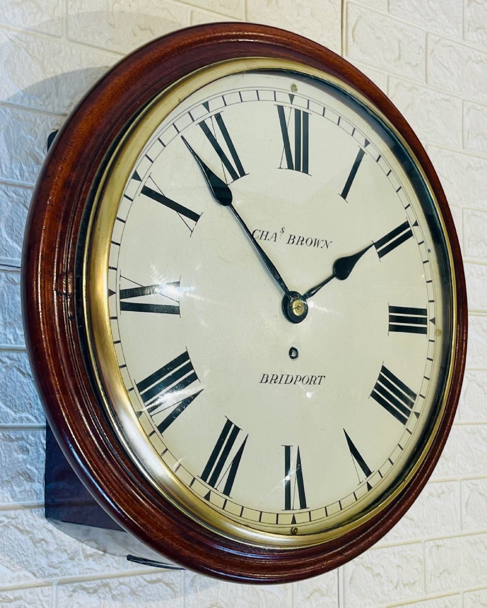 A circular Georgian fusee wall clock with a dark mahogany frame, a cream painted dial with Roman numerals, and a polished brass bezel. View XI
