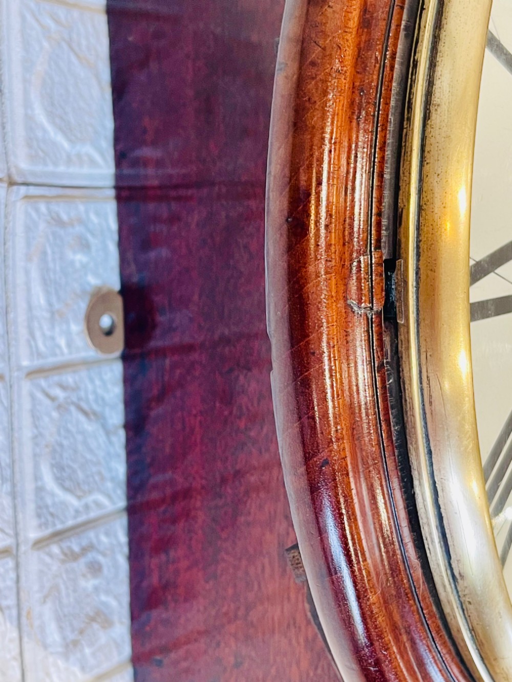 A circular Georgian fusee wall clock with a dark mahogany frame, a cream painted dial with Roman numerals, and a polished brass bezel. View XII