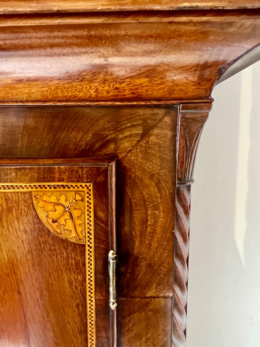 An antique Scottish Georgian mahogany longcase clock featuring a hand-painted dial, spiral turned columns, and marquetry inlay. View IX