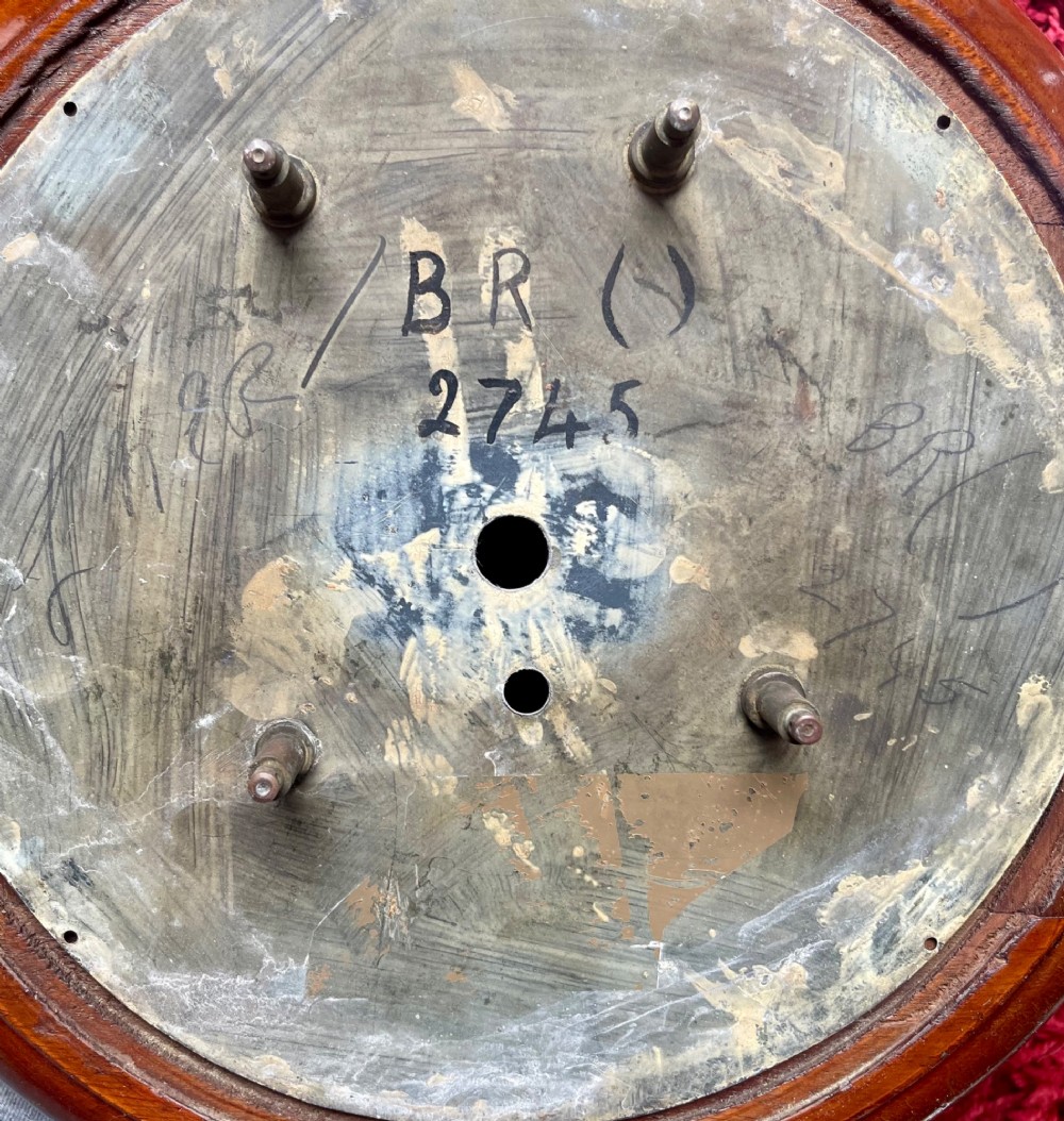 A circular 10-inch railway dial wall clock featuring a turned mahogany wooden surround, a brass bezel, and a cream dial marked B.R.(NE) with black Roman numerals. View XII