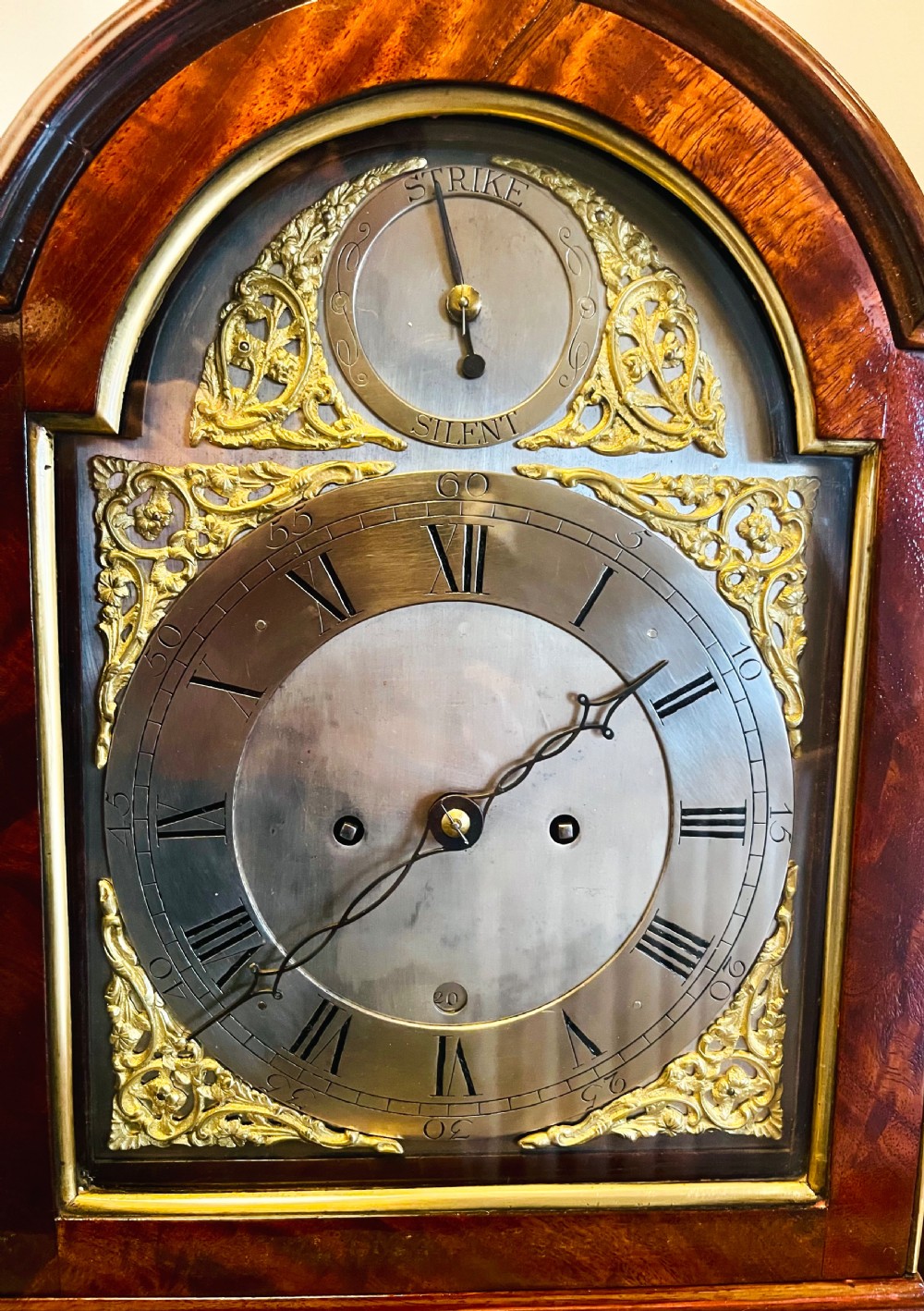 A George III mahogany bracket clock featuring an arched case with a brass top handle, gilt spandrels, and a silvered dial. View IV