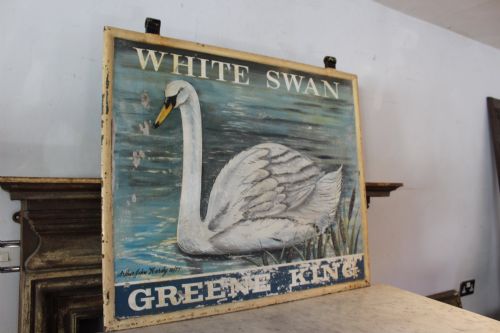 fig 5. A double-sided rectangular painted metal pub sign depicting a white swan floating on blue water with White Swan text above and Greene King text below.