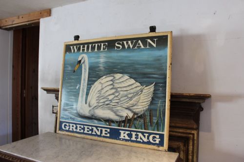 fig 7. A double-sided rectangular painted metal pub sign depicting a white swan floating on blue water with White Swan text above and Greene King text below.