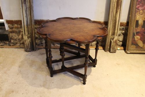 fig 1. A late Victorian walnut occasional table featuring a scalloped multi-lobed top with a raised rim, supported by turned legs and cross stretchers.