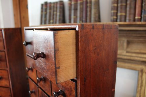 fig 5. A pair of matching early nineteenth-century tabletop wooden apothecary chests featuring multiple small drawers with turned wooden knobs and a warm brown finish.