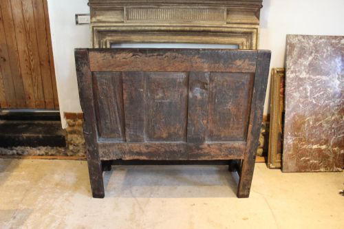 fig 7. A dark oak 17th-century style settle bench with a three-panel backrest, shaped armrests, and wooden stretchers.