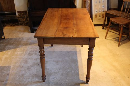 fig 2. A rectangular French cherry wood dining table featuring four turned legs and a single frieze drawer.