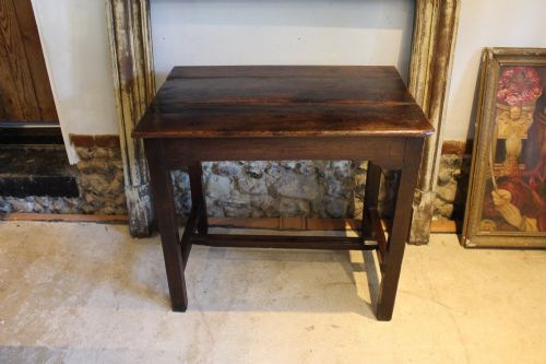 fig 1. A dark oak George I side table featuring a rectangular plank top, pegged mortise and tenon joinery, and square legs joined by lower stretchers.