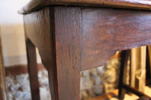 fig 3. A dark oak George I side table featuring a rectangular plank top, pegged mortise and tenon joinery, and square legs joined by lower stretchers.