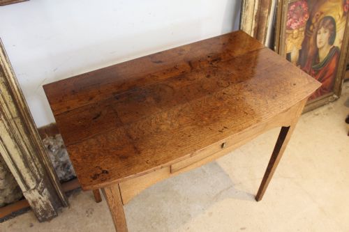 fig 3. A George III country oak side table featuring a single frieze drawer with a brass drop handle, a shaped apron, and four straight legs.