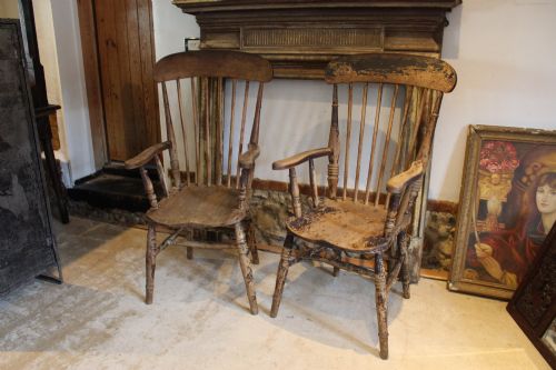 fig 1. A pair of late 19th-century Windsor armchairs featuring shaped elm seats, spindle backs, turned legs, and distressed dark brown patinated finish.