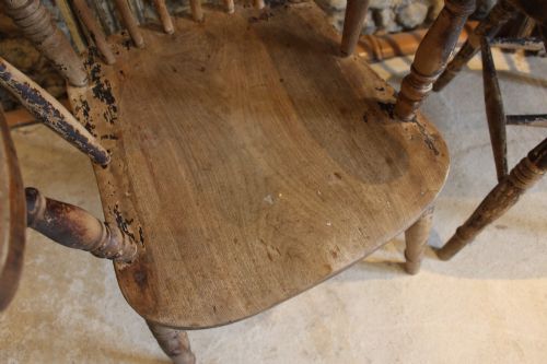 fig 2. A pair of late 19th-century Windsor armchairs featuring shaped elm seats, spindle backs, turned legs, and distressed dark brown patinated finish.