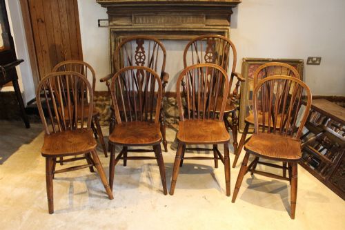fig 2. A set of eight Edwardian elm and beech Windsor dining chairs, including two armchairs and six side chairs, featuring hoop backs with spindle uprights and turned legs.