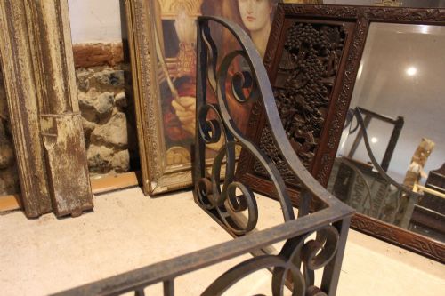 fig 1. A large dark steel fire fender featuring decorative scrolling ironwork along the front and side returns.