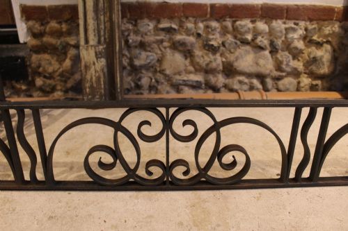 fig 4. A large dark steel fire fender featuring decorative scrolling ironwork along the front and side returns.