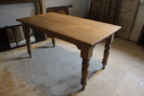 fig 5. An Edwardian rectangular pitch pine dining table with a thick plank top and four stout turned legs.
