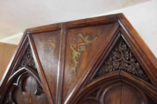 fig 3. A pair of arched dark oak architectural panels featuring carved Gothic tracery and polychrome paintings of mounted medieval knights and heraldic shields.