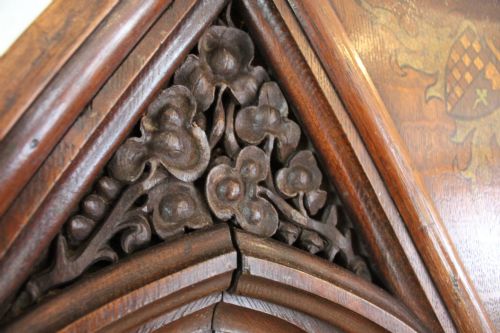 fig 7. A pair of arched dark oak architectural panels featuring carved Gothic tracery and polychrome paintings of mounted medieval knights and heraldic shields.