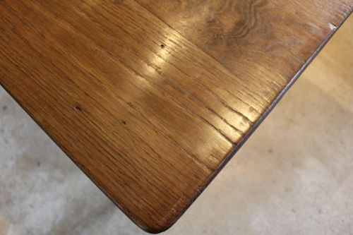 fig 6. An antique French oak refectory dining table featuring a solid two-plank top, a side frieze drawer, and square tapered legs.