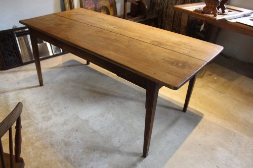 fig 8. An antique French oak refectory dining table featuring a solid two-plank top, a side frieze drawer, and square tapered legs.
