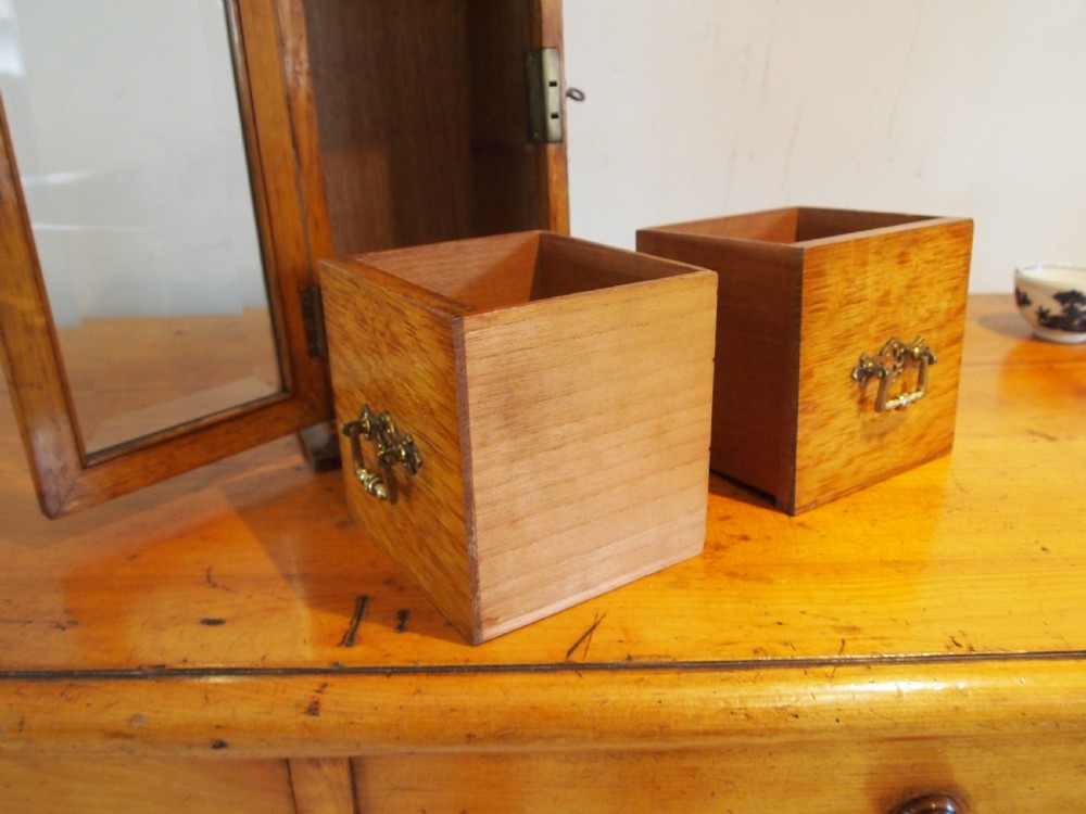A tall Victorian oak collectors chest with an arched glass door enclosing internal drawers fitted with brass handles. View XI