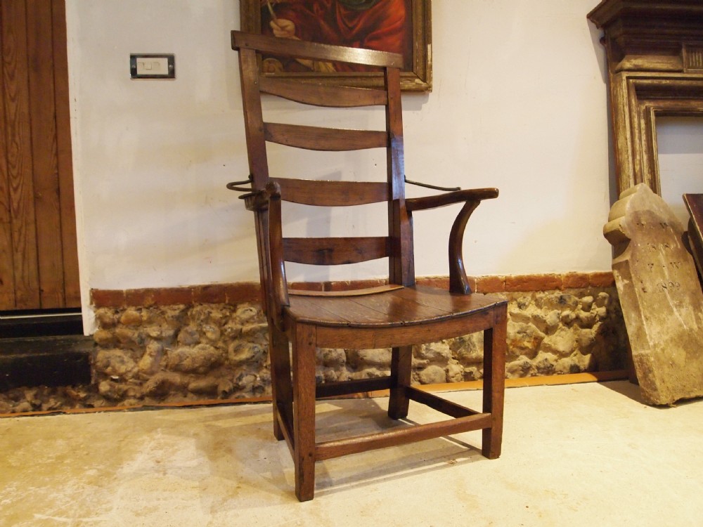 A late 18th-century George III oak and elm reclining ladderback armchair with curved arms and iron side stays. View III
