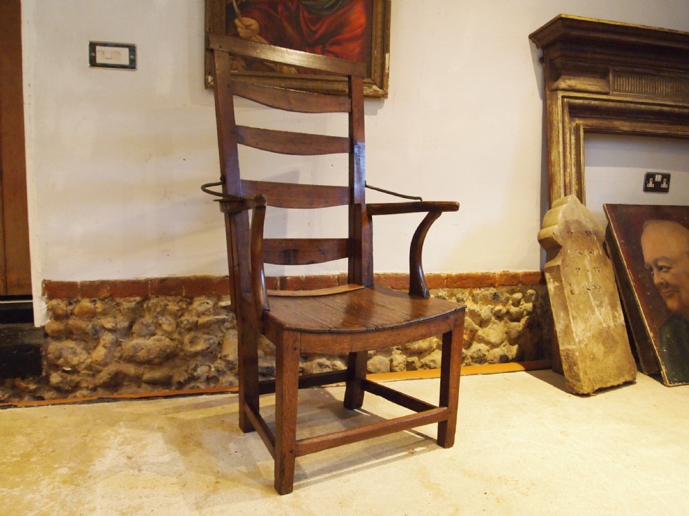 A late 18th-century George III oak and elm reclining ladderback armchair with curved arms and iron side stays. View VII
