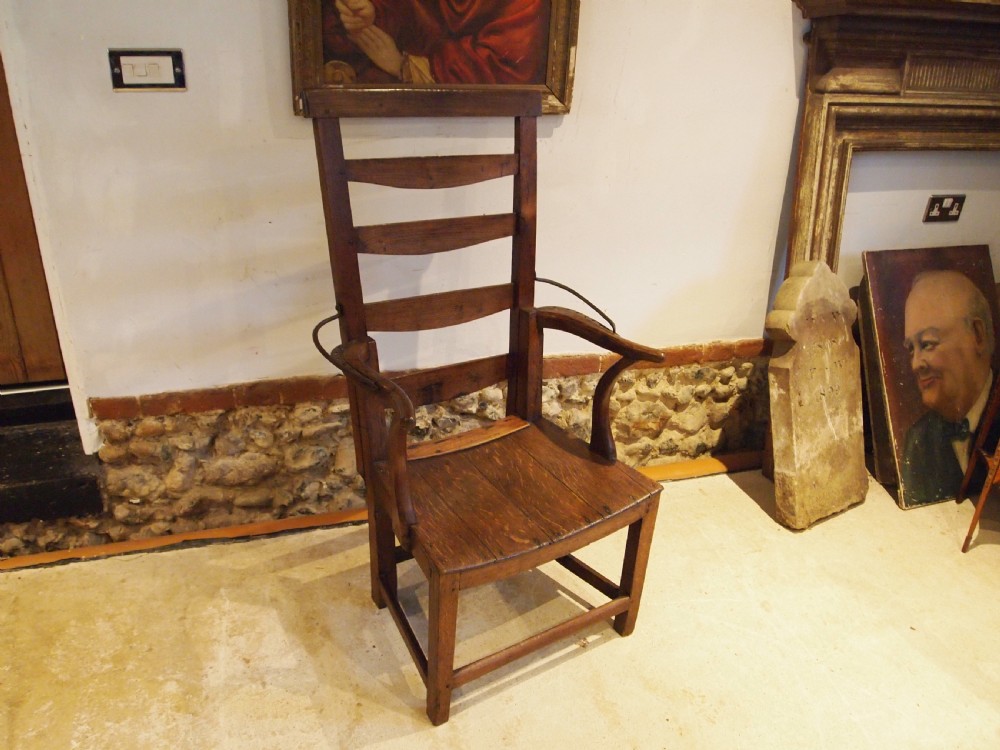 A late 18th-century George III oak and elm reclining ladderback armchair with curved arms and iron side stays. View VIII