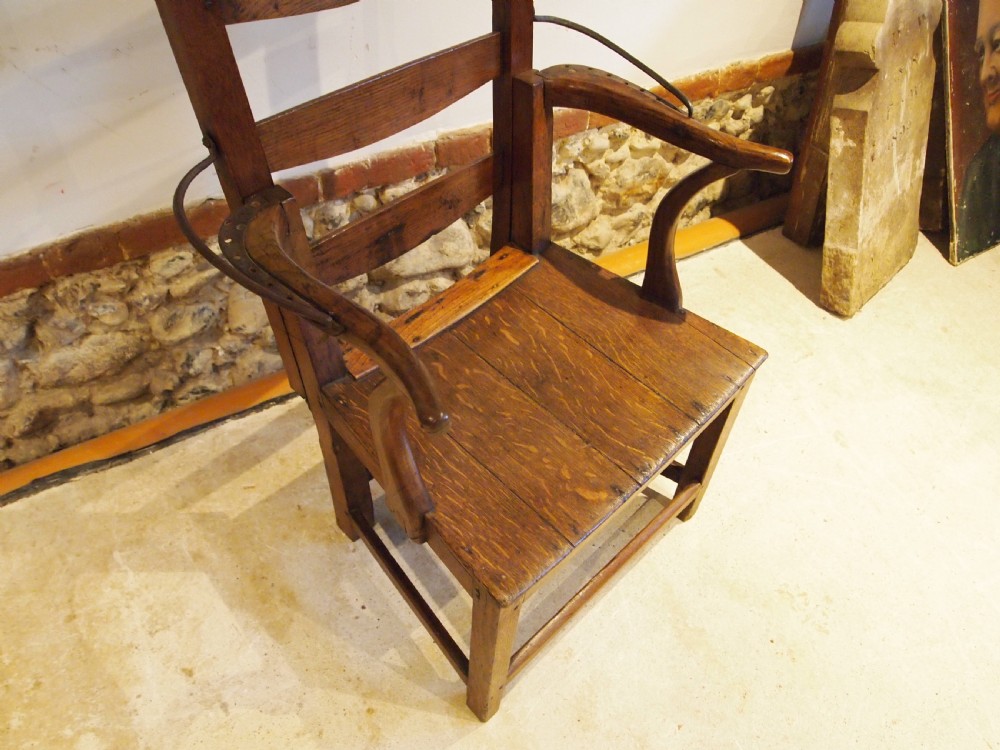 A late 18th-century George III oak and elm reclining ladderback armchair with curved arms and iron side stays. View IX