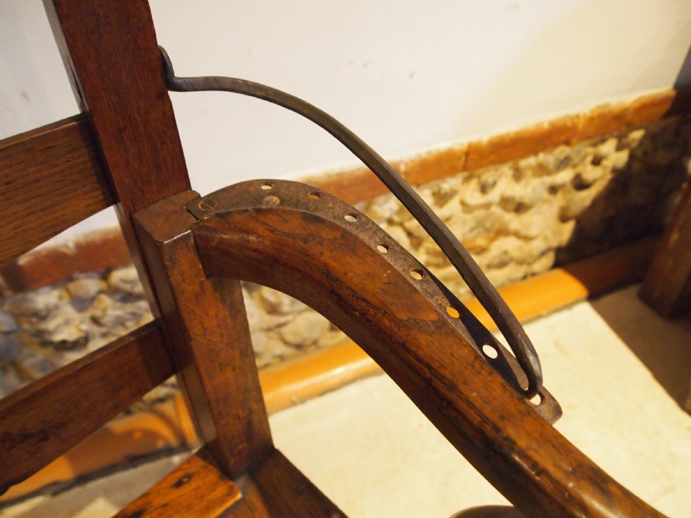 A late 18th-century George III oak and elm reclining ladderback armchair with curved arms and iron side stays. View XI