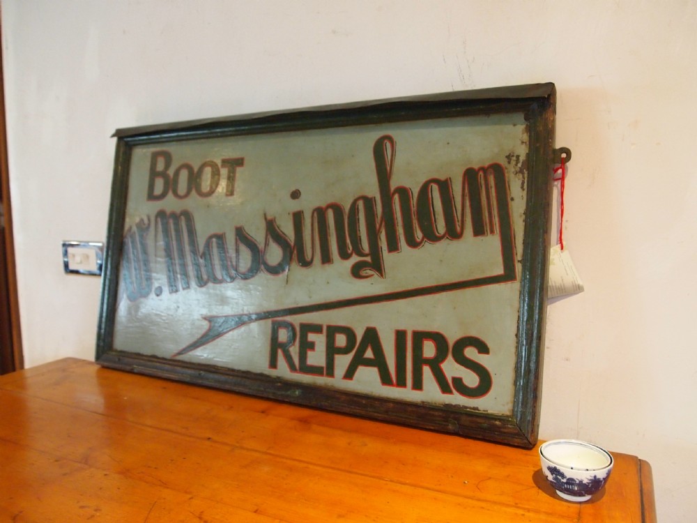 A rectangular hand-painted antique metal shop sign featuring black lettering outlined in red reading Boot W Massingham Repairs against a grey background within a dark metal frame. View II