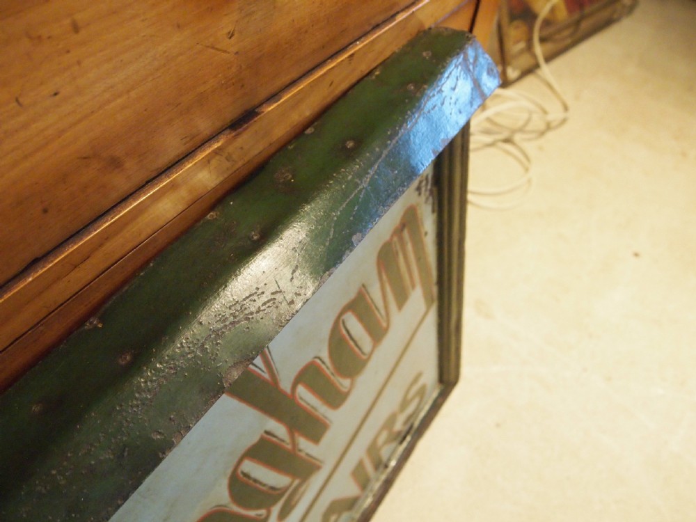 A rectangular hand-painted antique metal shop sign featuring black lettering outlined in red reading Boot W Massingham Repairs against a grey background within a dark metal frame. View VIII